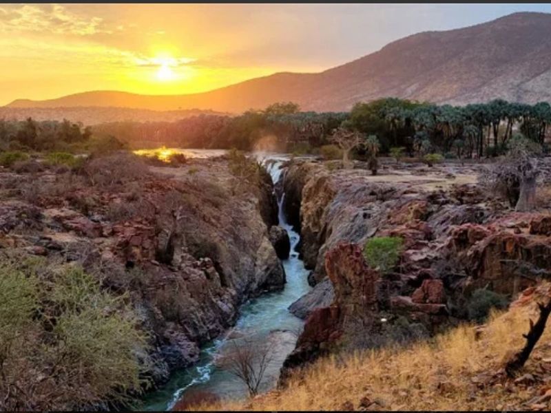 A scenic landscape view featuring a river flowing through a rocky gorge at sunset, showcasing the natural beauty of the surrounding terrain.