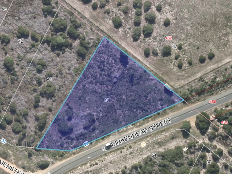 Aerial view of a vacant commercial plot highlighting the property boundaries and street access.
