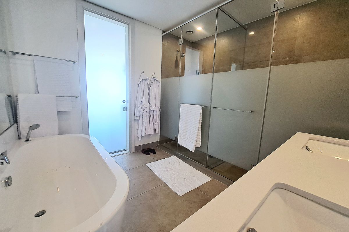 Modern bathroom featuring a freestanding bathtub, a spacious glass-enclosed shower, and a double vanity with contemporary finishes.