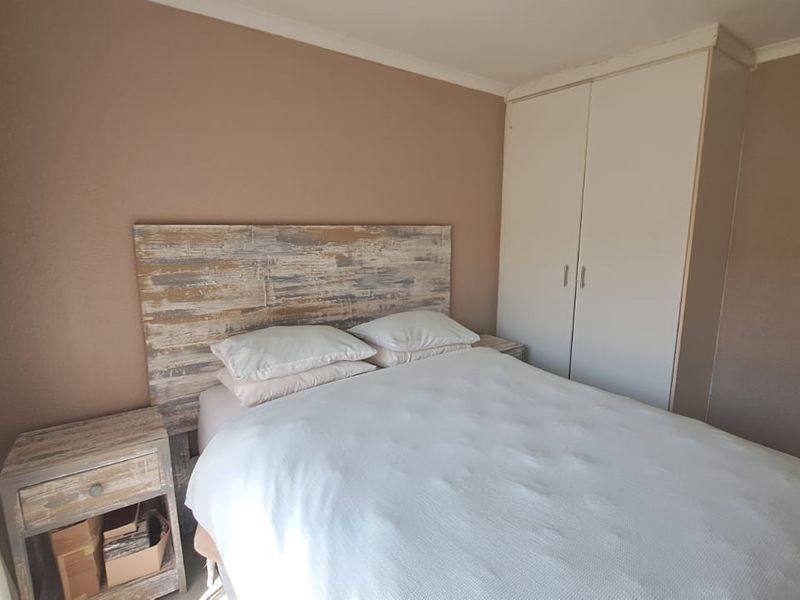 A bedroom featuring a built-in wardrobe and neutral wall finishes, providing a functional and comfortable sleeping space.