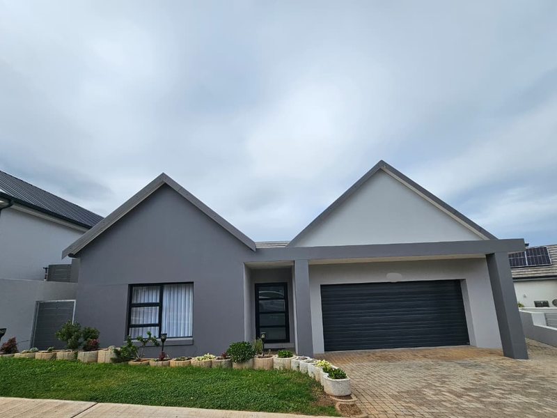 Modern single-story residential home featuring a double garage, paved driveway, and contemporary grey facade with clean architectural lines.