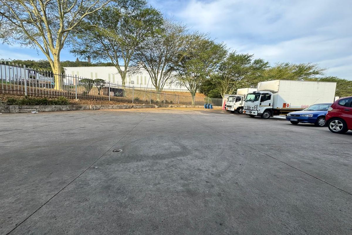 Spacious industrial concrete yard area providing ample space for vehicle maneuvering and parking, enclosed by perimeter fencing.