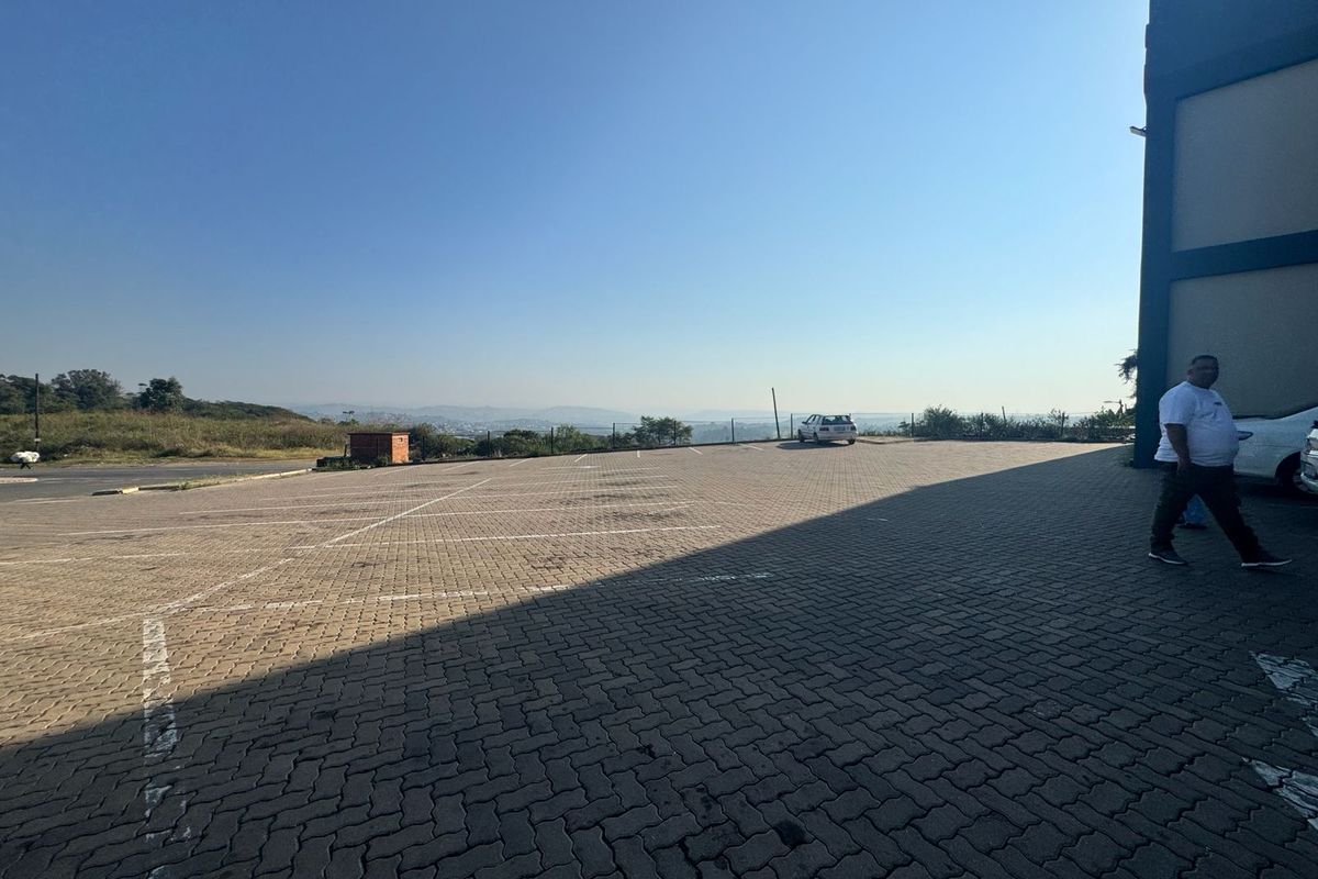 An outdoor paved parking area adjacent to the building, featuring open space and distant landscape views.