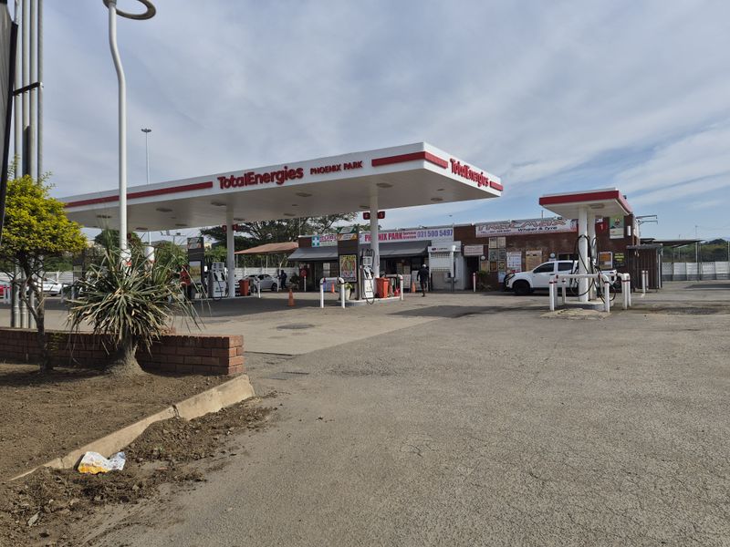 A functional TotalEnergies service station featuring a large fuel canopy, multiple fuel pumps, and an attached service building with paved forecourt access.