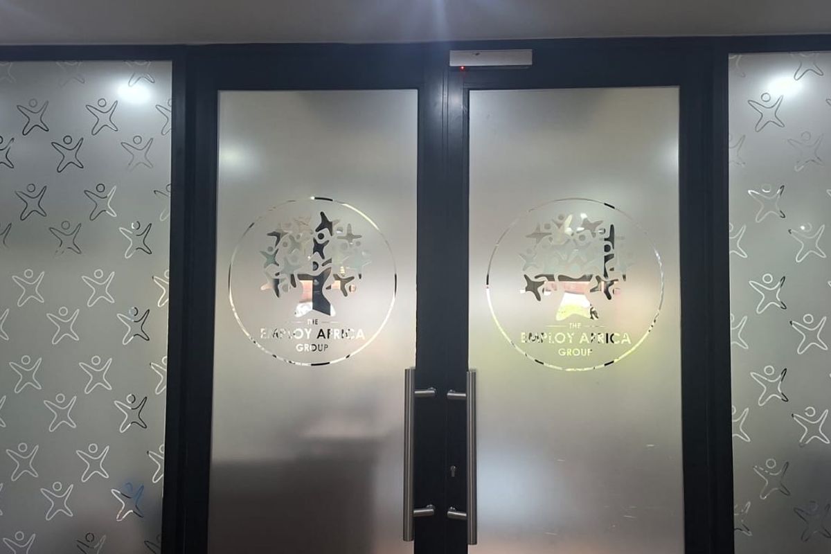 Professional office entrance featuring double doors with frosted glass panels and branded company decals.