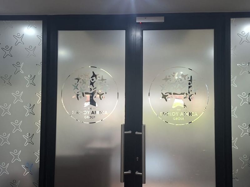 Professional office entrance featuring double doors with frosted glass panels and branded company decals.