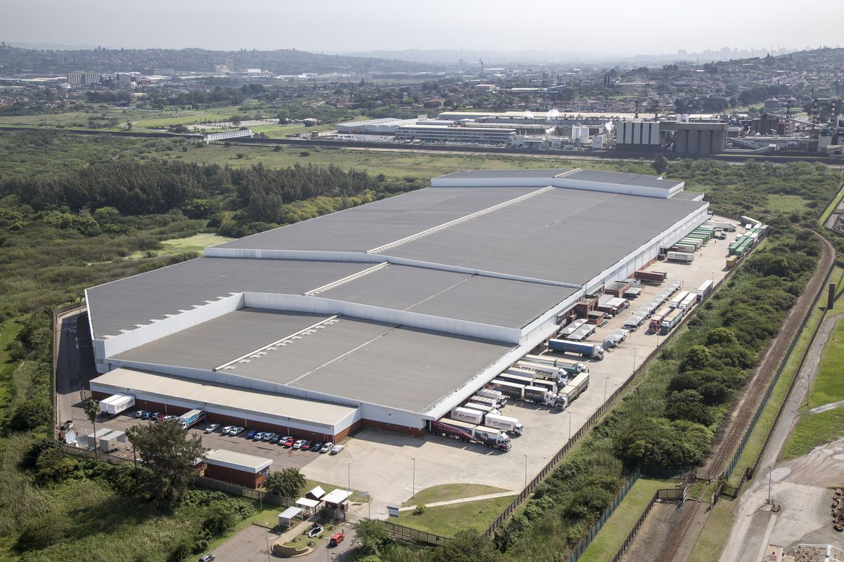 Aerial view of a large industrial warehouse facility featuring extensive loading docks, paved yard space, and secure perimeter access.