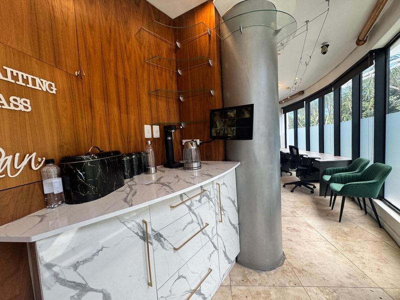 Modern office space featuring built-in marble-effect cabinetry, a prominent structural column, and large windows providing ample natural light.