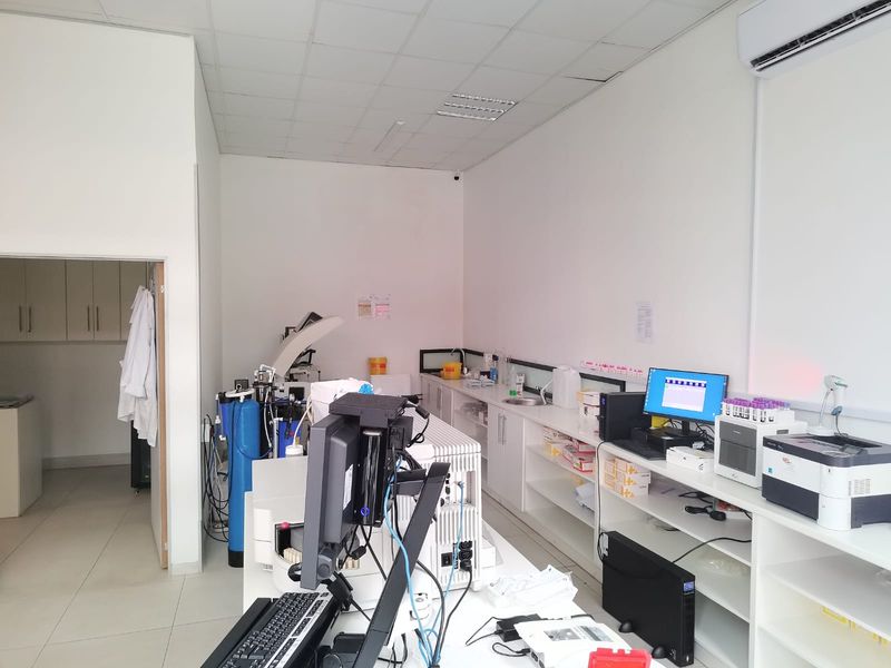 A functional commercial laboratory or medical utility space featuring built-in cabinetry, a sink, and integrated air conditioning.