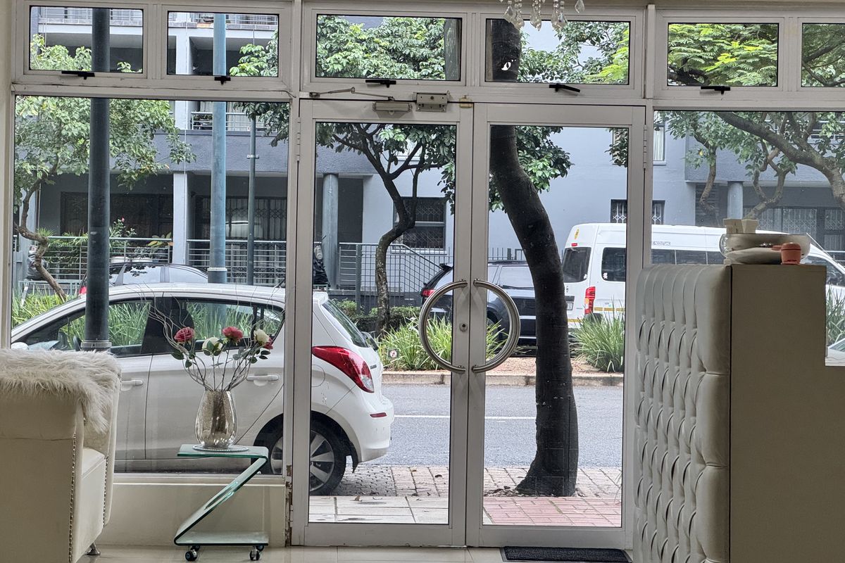 Main entrance area featuring aluminium-framed glass doors and large windows, providing clear visibility to the street and exterior surroundings.