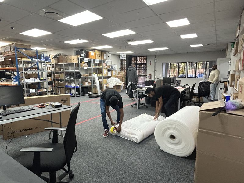 A functional commercial utility and storage space featuring suspended ceilings, recessed lighting, and industrial metal shelving units for organized inventory management.