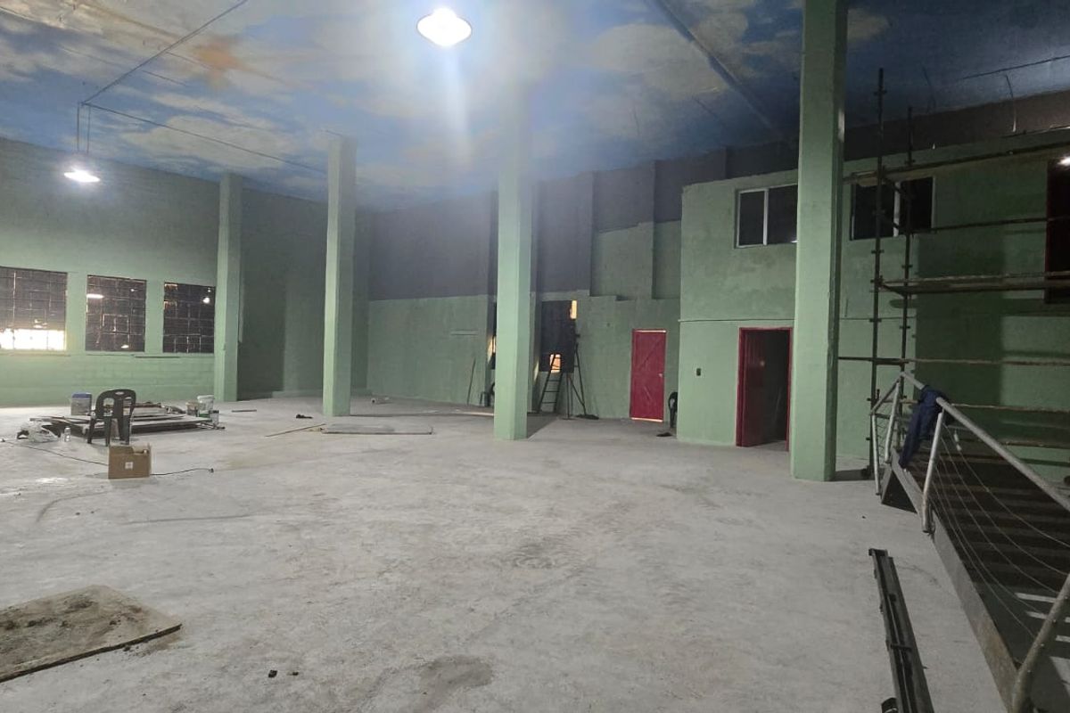 Large open-plan industrial utility space featuring concrete flooring, structural columns, and high ceilings, currently undergoing renovation and maintenance.