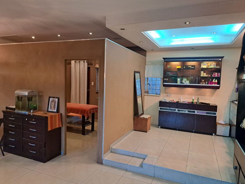 Office space featuring a raised platform area, built-in cabinetry, recessed lighting, and a partitioned room with tiled flooring throughout.