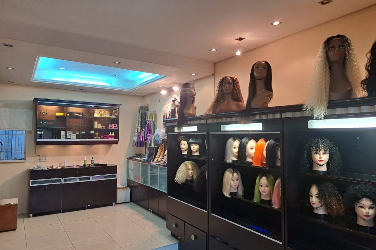 A commercial office space featuring built-in display cabinetry, recessed ceiling lighting, and tiled flooring, currently utilized for retail display.