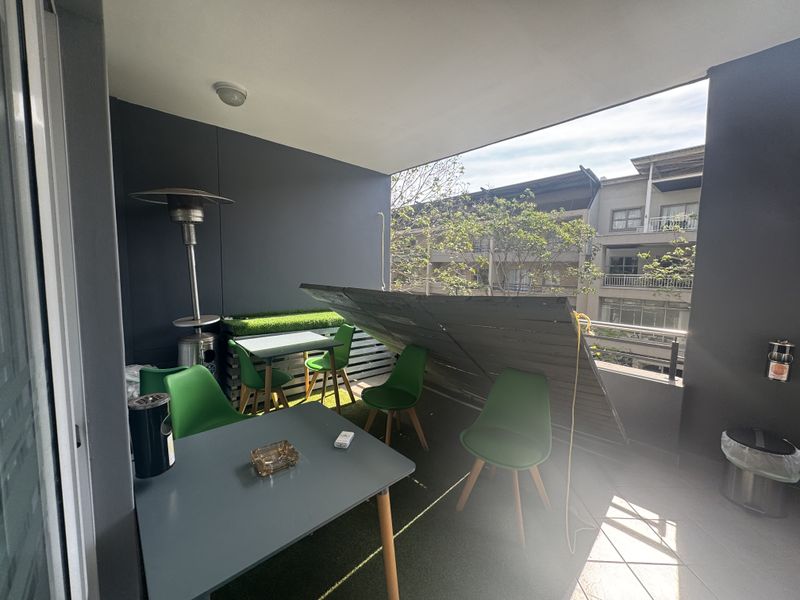 Covered balcony area featuring tiled flooring and a railing, currently showing a damaged wooden privacy screen.