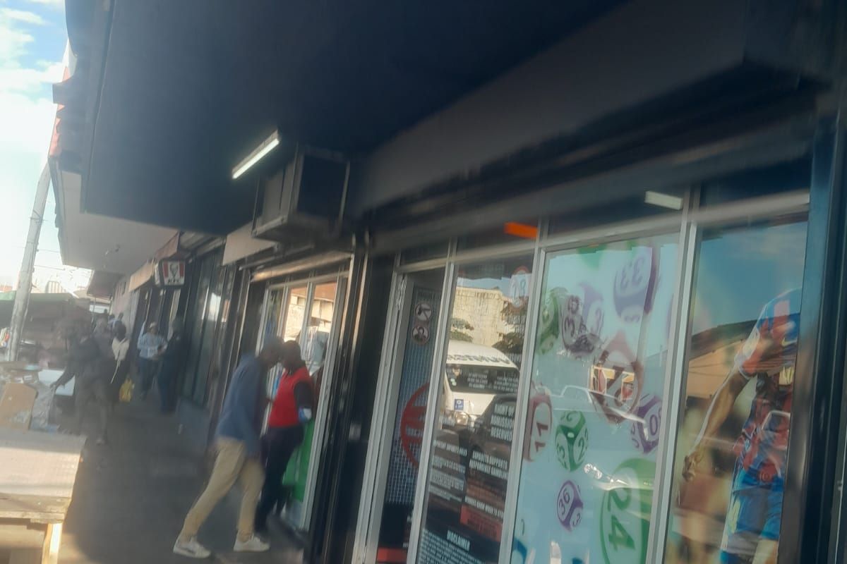 Street-level view of a retail storefront featuring a large glass display window and a prominent overhead awning.