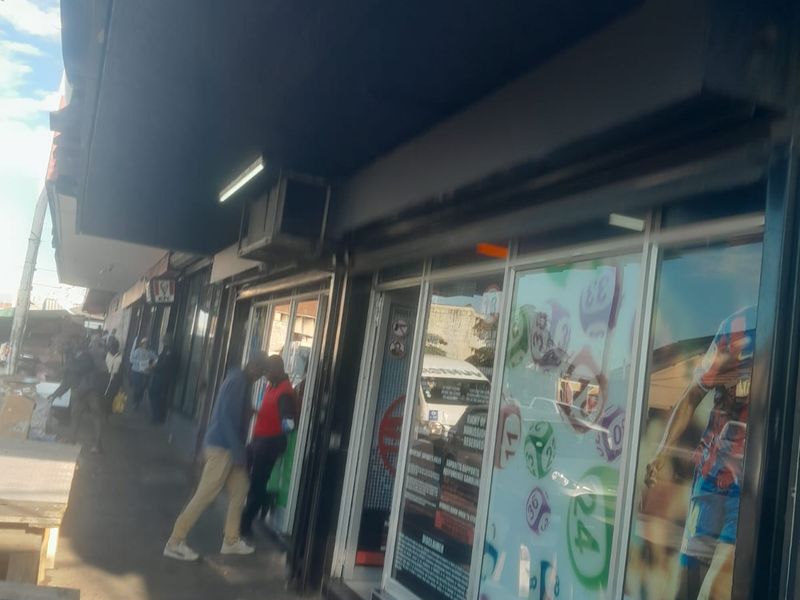 Street-level view of a retail storefront featuring a large glass display window and a prominent overhead awning.