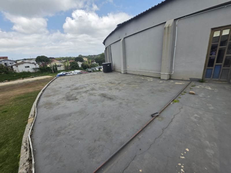 An expansive outdoor concrete patio area featuring an external HVAC unit and direct access to the building interior.
