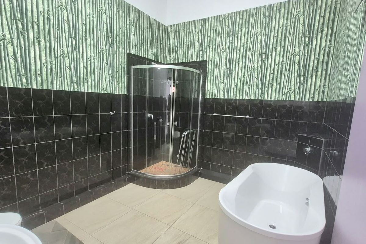Bathroom featuring a corner shower enclosure, a freestanding bathtub, and tiled flooring, currently requiring cosmetic updates to the wall finishes.