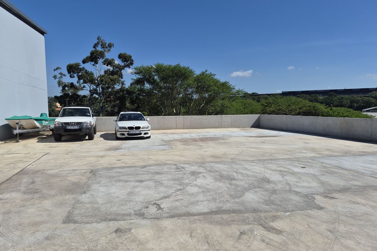 An expansive industrial outdoor paved area featuring a concrete surface and perimeter retaining wall, suitable for parking or storage.