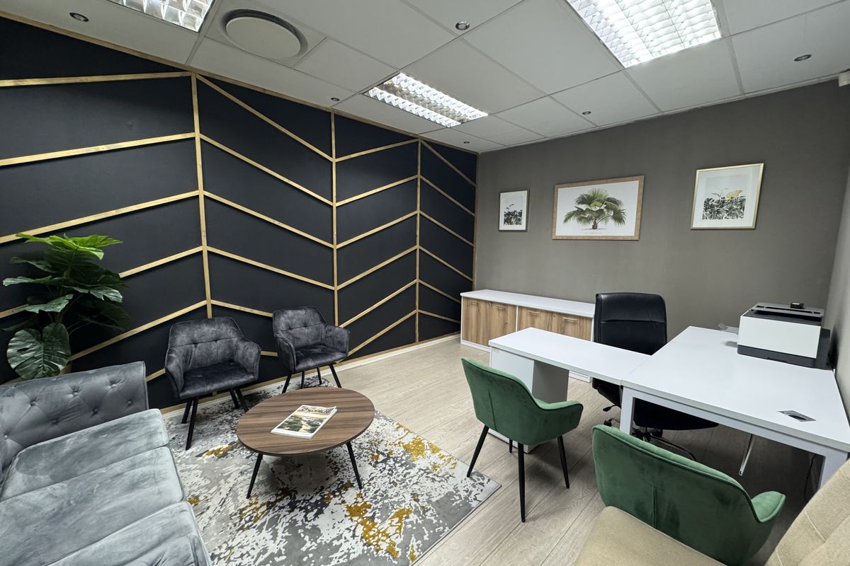 A well-maintained office space featuring modern decorative wall paneling, suspended ceilings with recessed lighting, and built-in storage cabinetry.