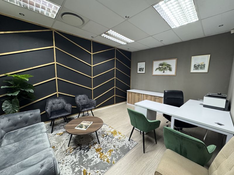 A well-maintained office space featuring modern decorative wall paneling, suspended ceilings with recessed lighting, and built-in storage cabinetry.