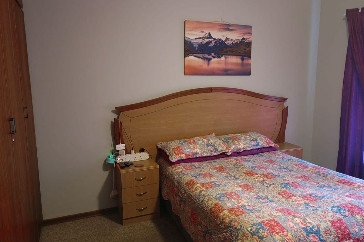 A functional bedroom featuring carpet flooring and a built-in wardrobe, providing essential storage space.