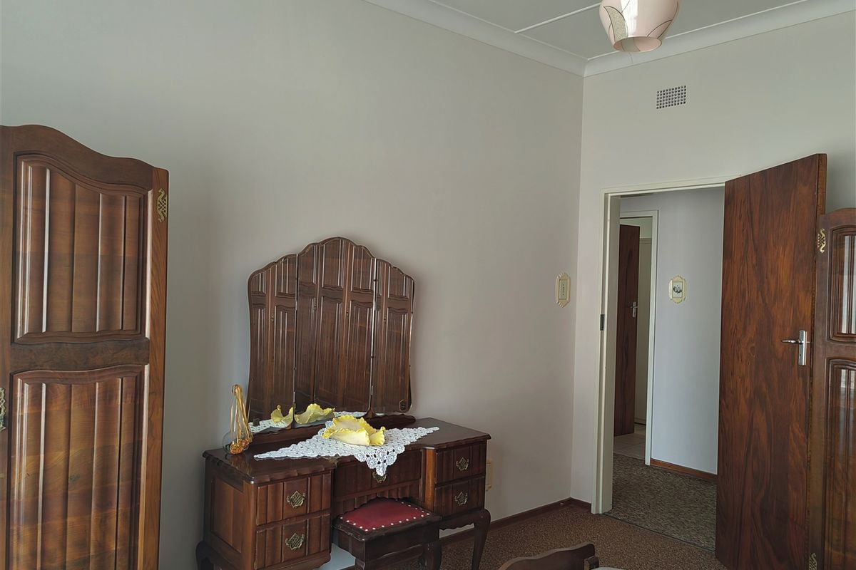 A bedroom featuring neutral wall finishes, carpeted flooring, and a standard doorway leading to an adjacent hallway.