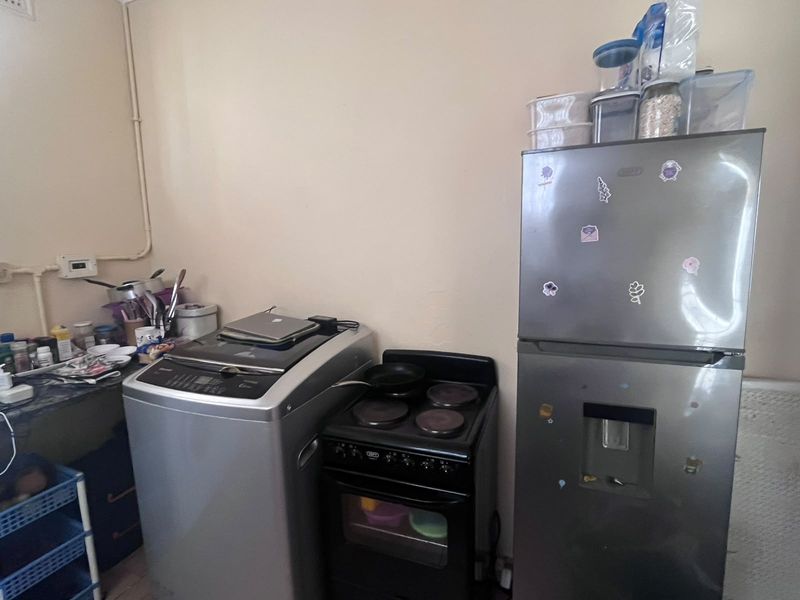 A functional kitchen area featuring a built-in countertop, electric stove, and oven, providing essential cooking infrastructure for the apartment.
