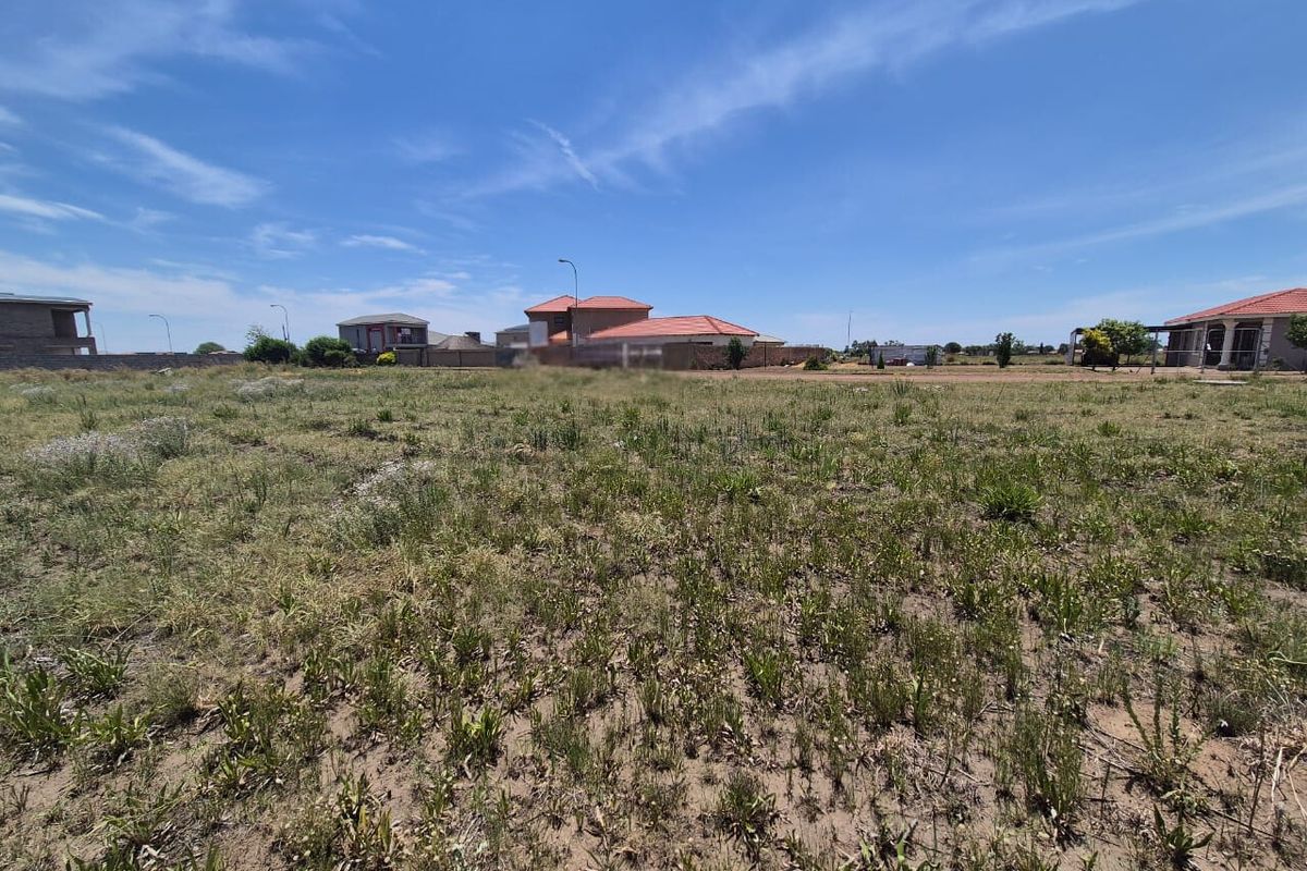 A view of a vacant residential plot of land in a developed neighborhood, suitable for new construction.