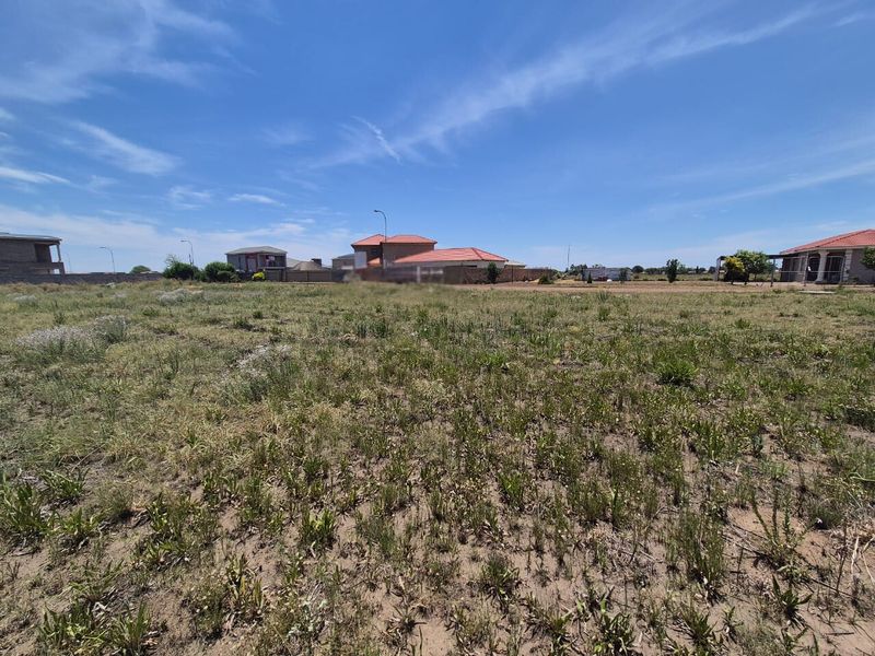A view of a vacant residential plot of land in a developed neighborhood, suitable for new construction.
