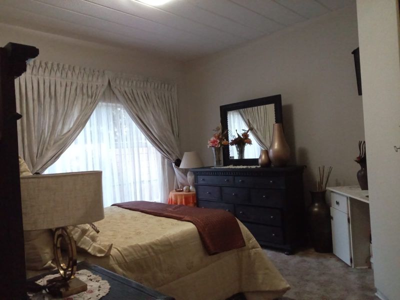 A standard bedroom featuring carpeted flooring and a built-in cupboard, offering a functional living space with neutral wall finishes.