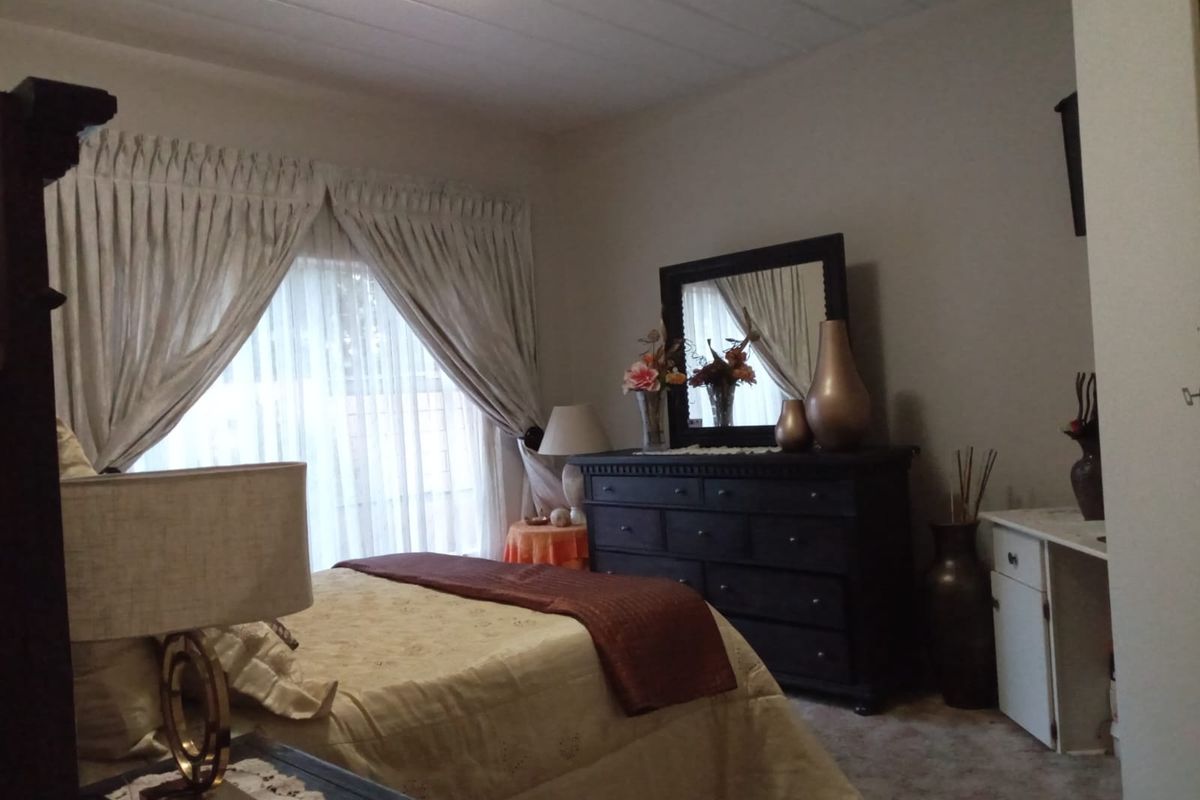 A standard bedroom featuring carpeted flooring and a built-in cupboard, offering a functional living space with neutral wall finishes.