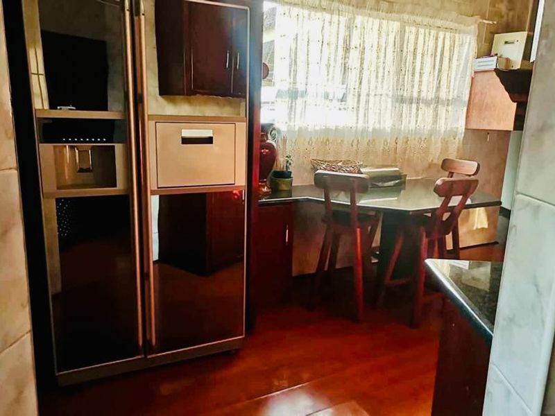 A functional kitchen area featuring built-in cabinetry, tiled wall finishes, and laminate flooring, providing a practical space for meal preparation.