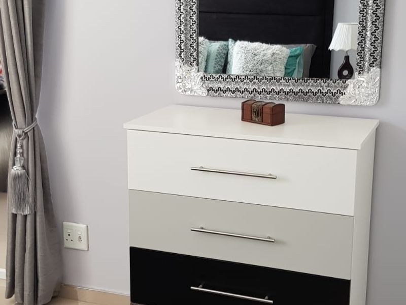 A bedroom interior featuring tiled flooring and a neutral wall finish, providing a clean and functional space.