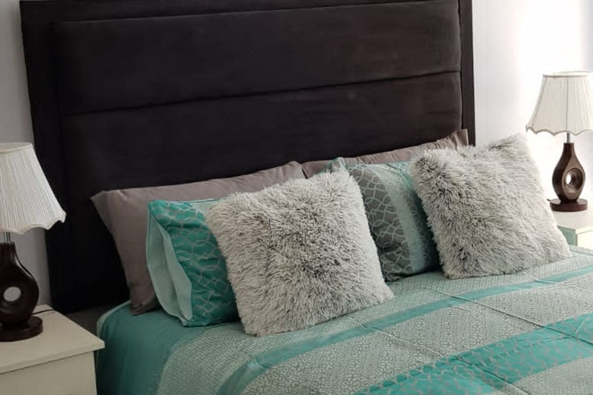A well-maintained bedroom featuring a decorative ceiling cornice and neutral wall finishes.