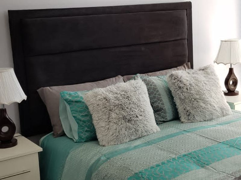 A well-maintained bedroom featuring a decorative ceiling cornice and neutral wall finishes.