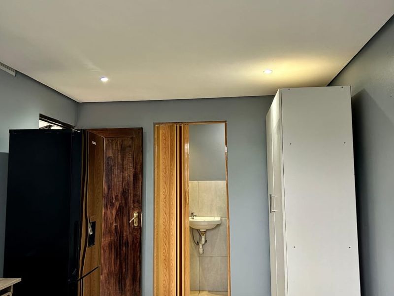 Bedroom featuring tiled flooring, built-in wardrobe, and an en-suite bathroom access via a folding door.