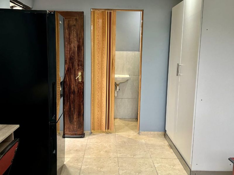 A bedroom featuring tiled flooring, recessed lighting, and a built-in wardrobe, with direct access to an en-suite bathroom area.