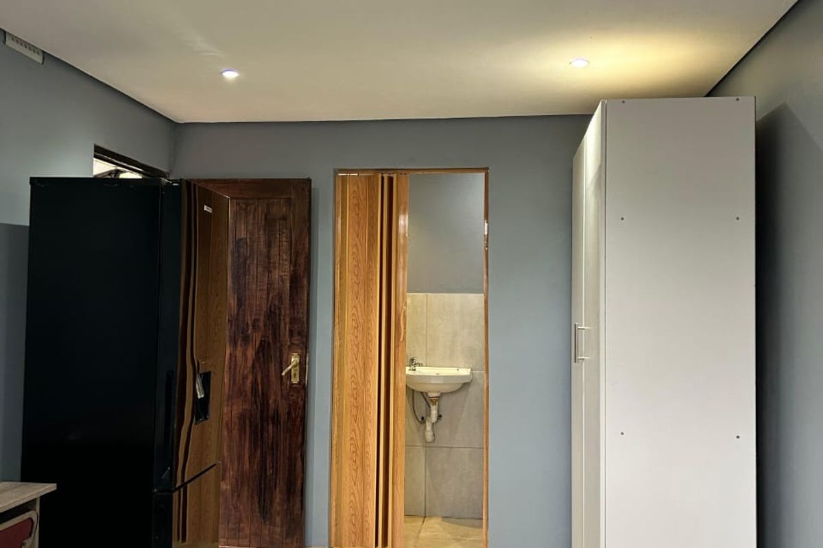 Bedroom featuring tiled flooring, recessed lighting, a built-in wardrobe, and an en-suite bathroom area accessed via a folding door.