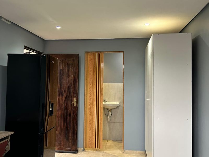 Bedroom featuring tiled flooring, recessed lighting, a built-in wardrobe, and an en-suite bathroom area accessed via a folding door.
