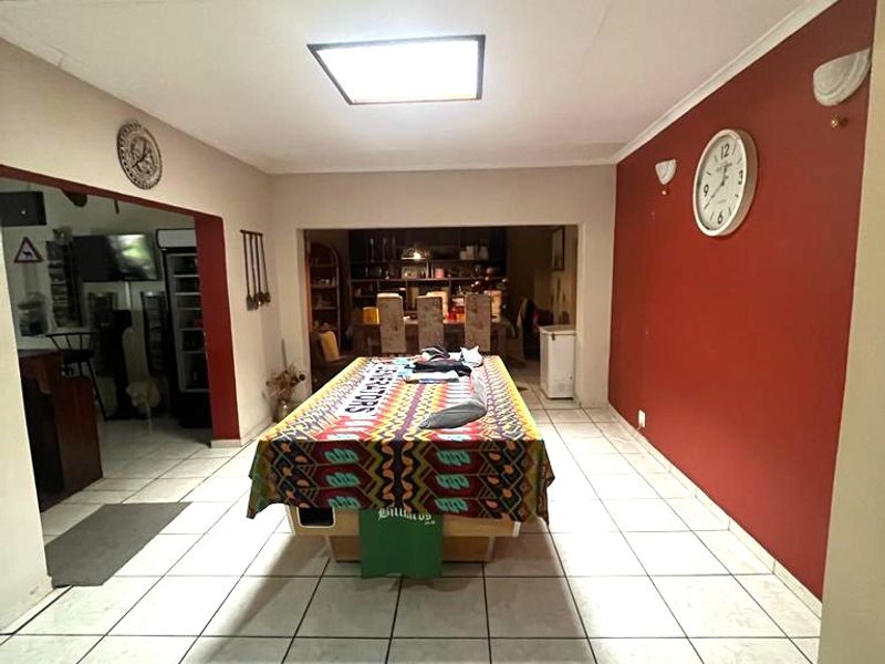 Spacious living area featuring tiled flooring and recessed ceiling lighting, providing a versatile space for entertainment and relaxation.