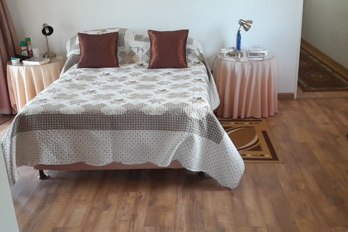 A bedroom featuring laminate flooring and a built-in wardrobe, offering a functional space with neutral wall finishes.