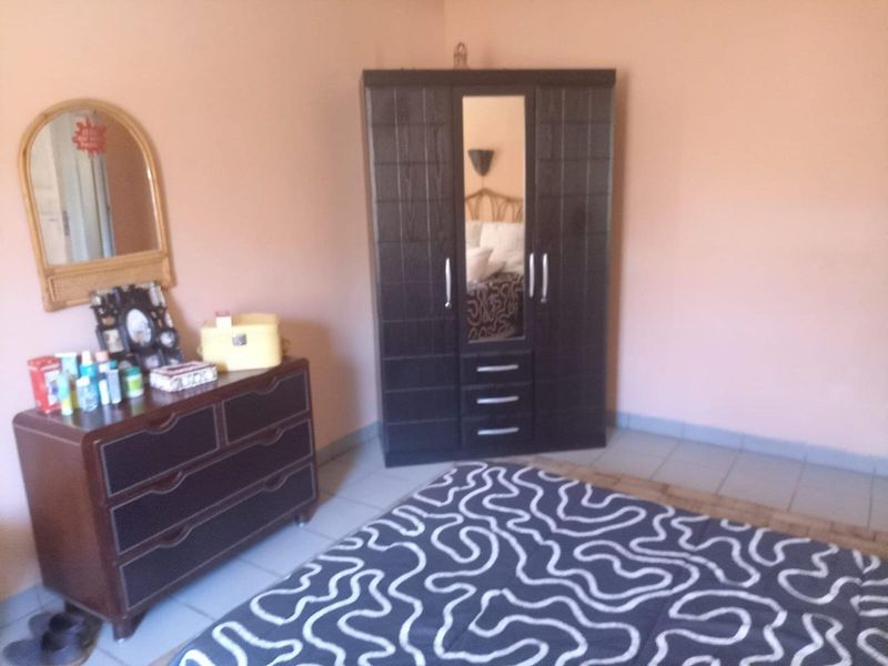 A bedroom featuring tiled flooring and neutral wall finishes, providing a functional space for rest.