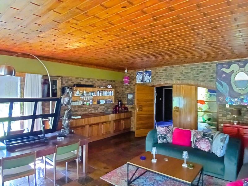 Spacious living area featuring a warm timber-clad ceiling, exposed brick walls, and custom built-in timber cabinetry, offering a unique and character-filled living space.