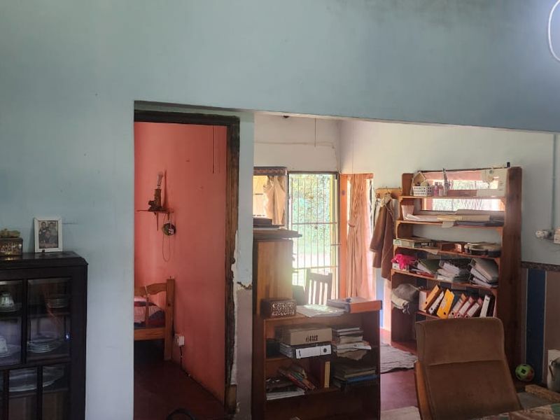 A living area with visible wall damage and dated finishes, offering potential for renovation and modernization to improve the overall aesthetic.