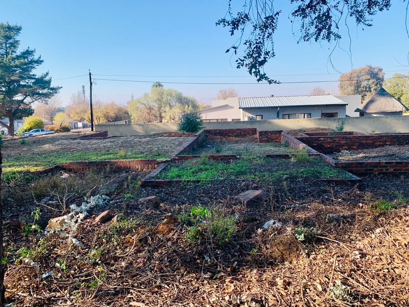 Vacant residential land featuring existing brick foundations and a perimeter wall, offering a cleared base for future development.