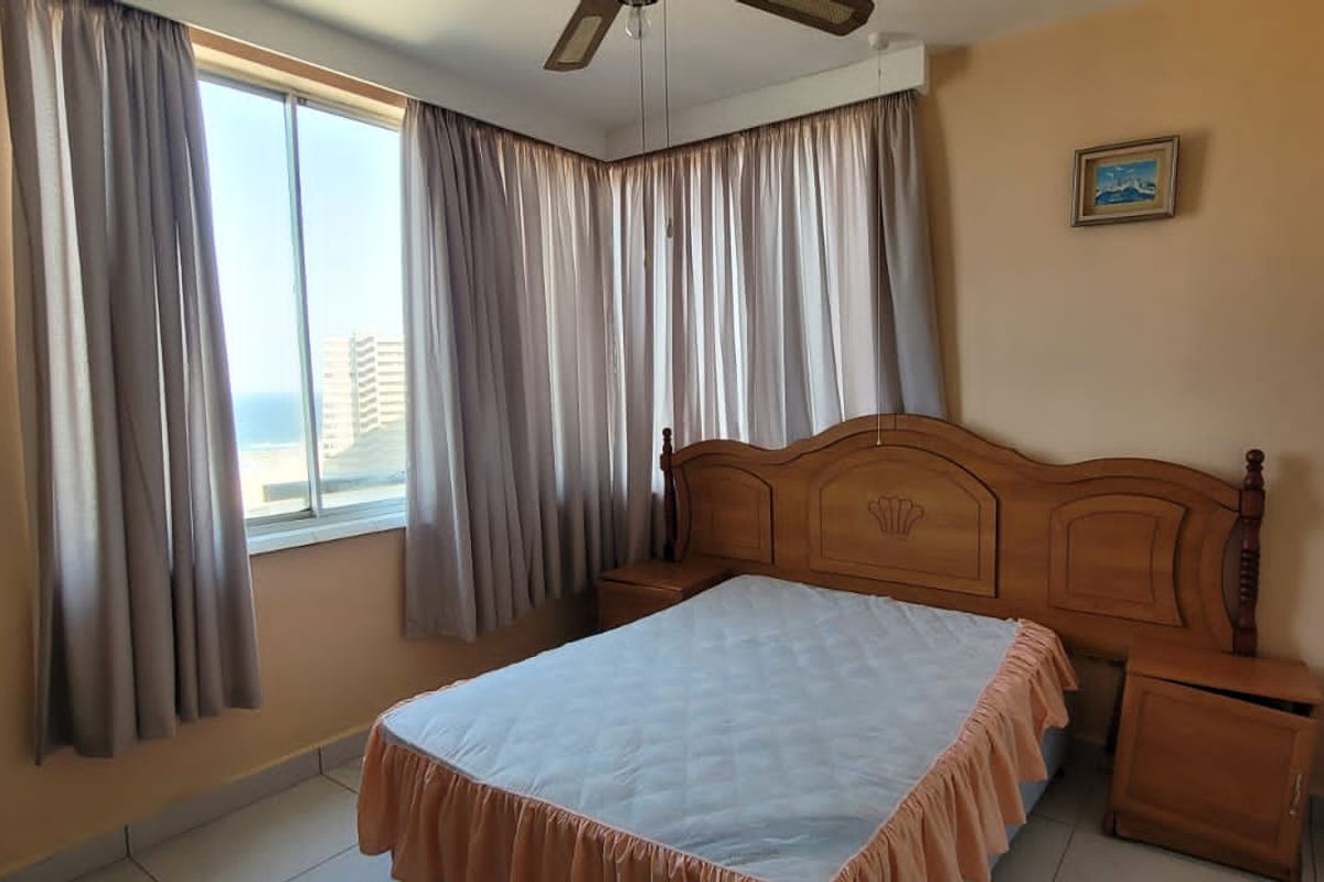 A bedroom featuring large windows with curtains, tiled flooring, and built-in cupboard space.