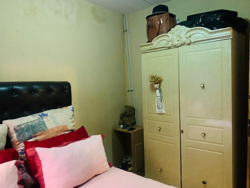 A bedroom featuring a built-in wardrobe and visible water staining on the wall surface.