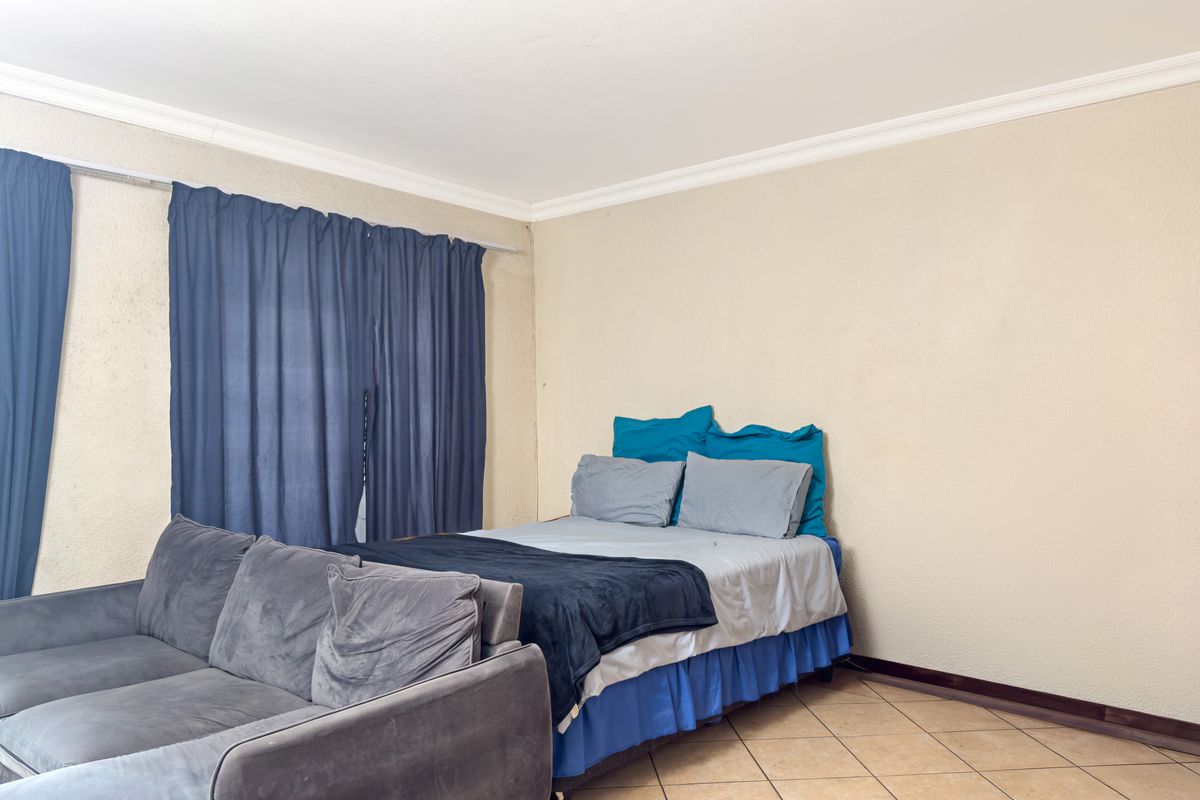 A bedroom featuring tiled flooring and cove cornicing, providing a functional space ready for cosmetic updates.